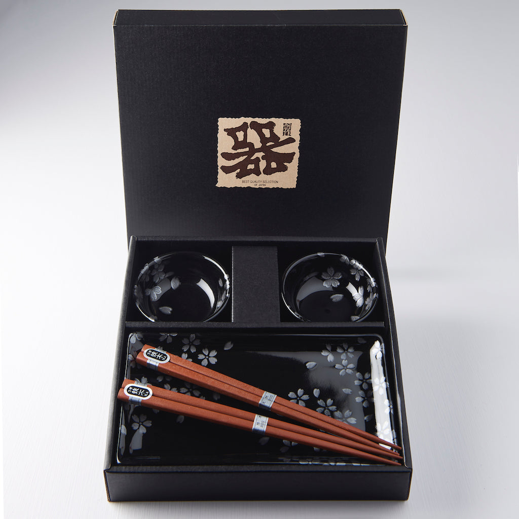 Four-piece Japanese sushi set with chopsticks, black sakura plate, and dipping bowls in gift box