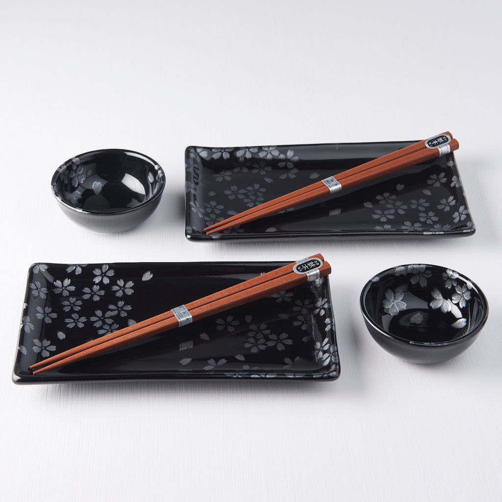 Four-piece Japanese sushi set with chopsticks, black sakura plate, and dipping bowls in gift box