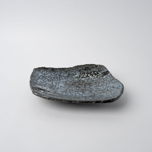 Handcrafted ceramic plate with organic shape and Shiranami grey-blue crackle glaze.