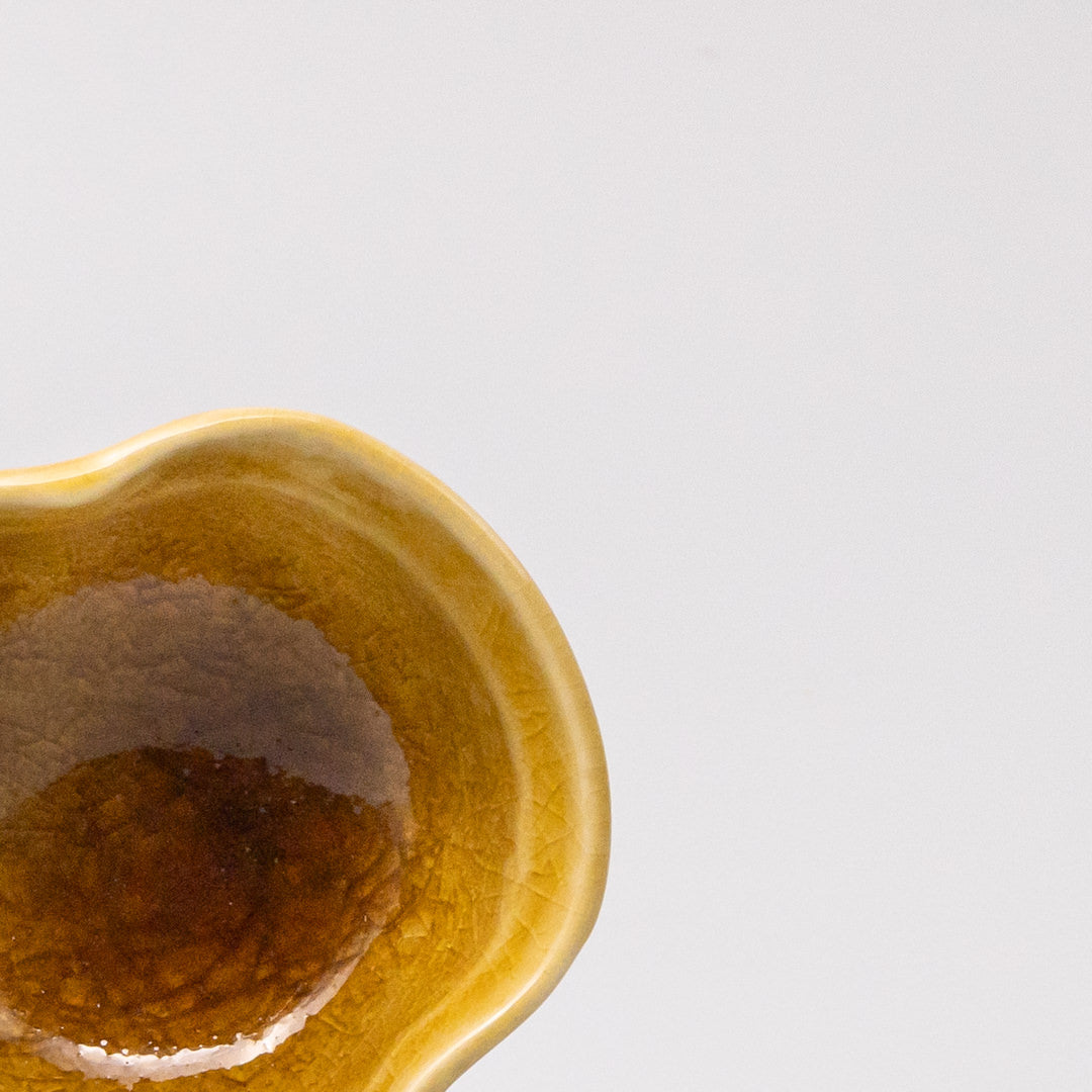 Small sauce bowl in warm amber glaze with softly curved edges