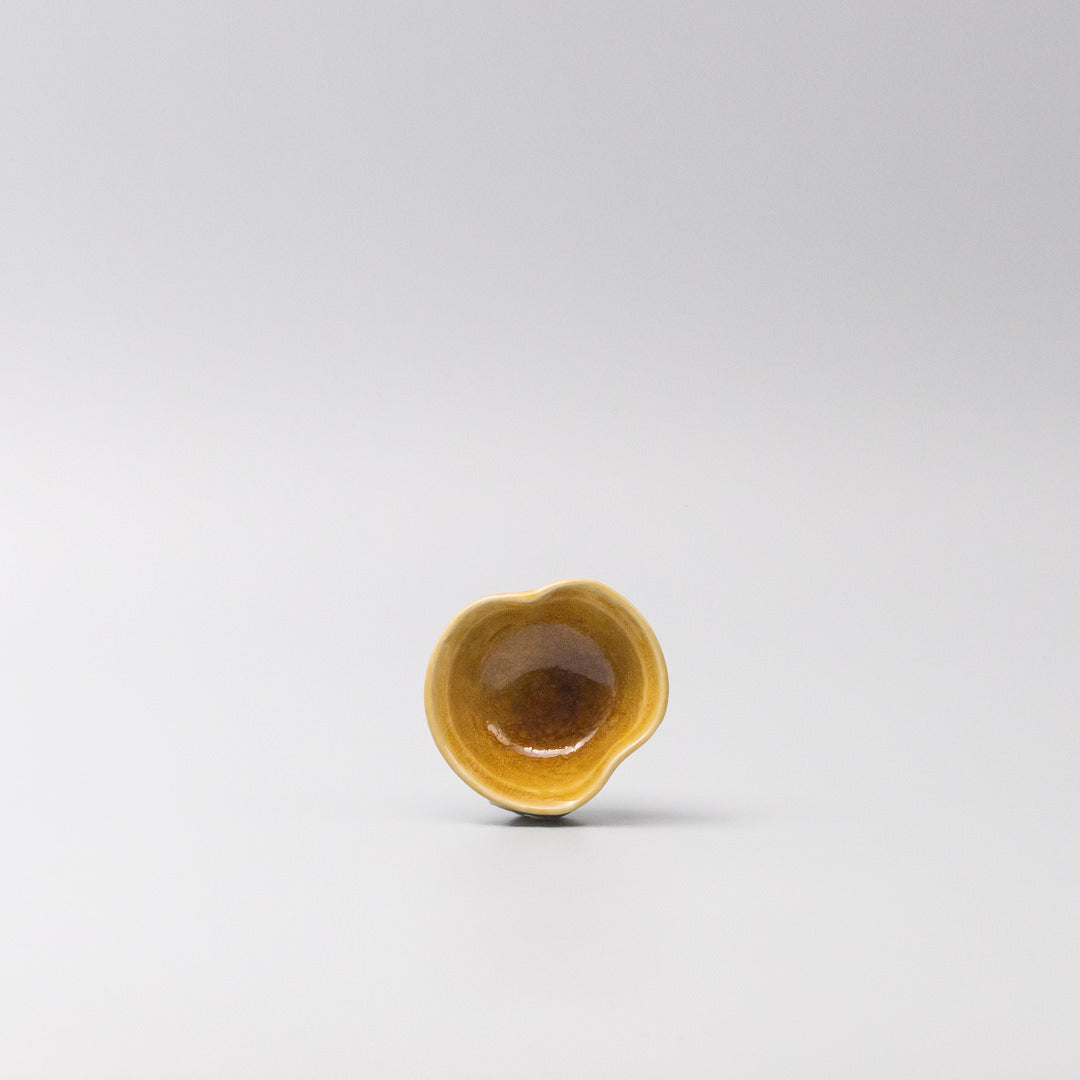 Small sauce bowl in warm amber glaze with softly curved edges