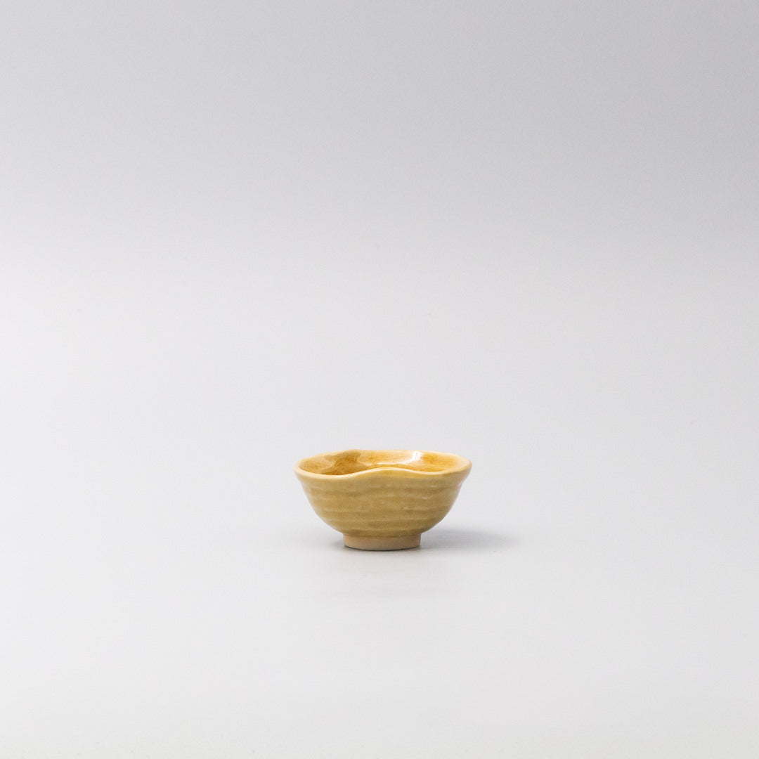 Small sauce bowl in warm amber glaze with softly curved edges