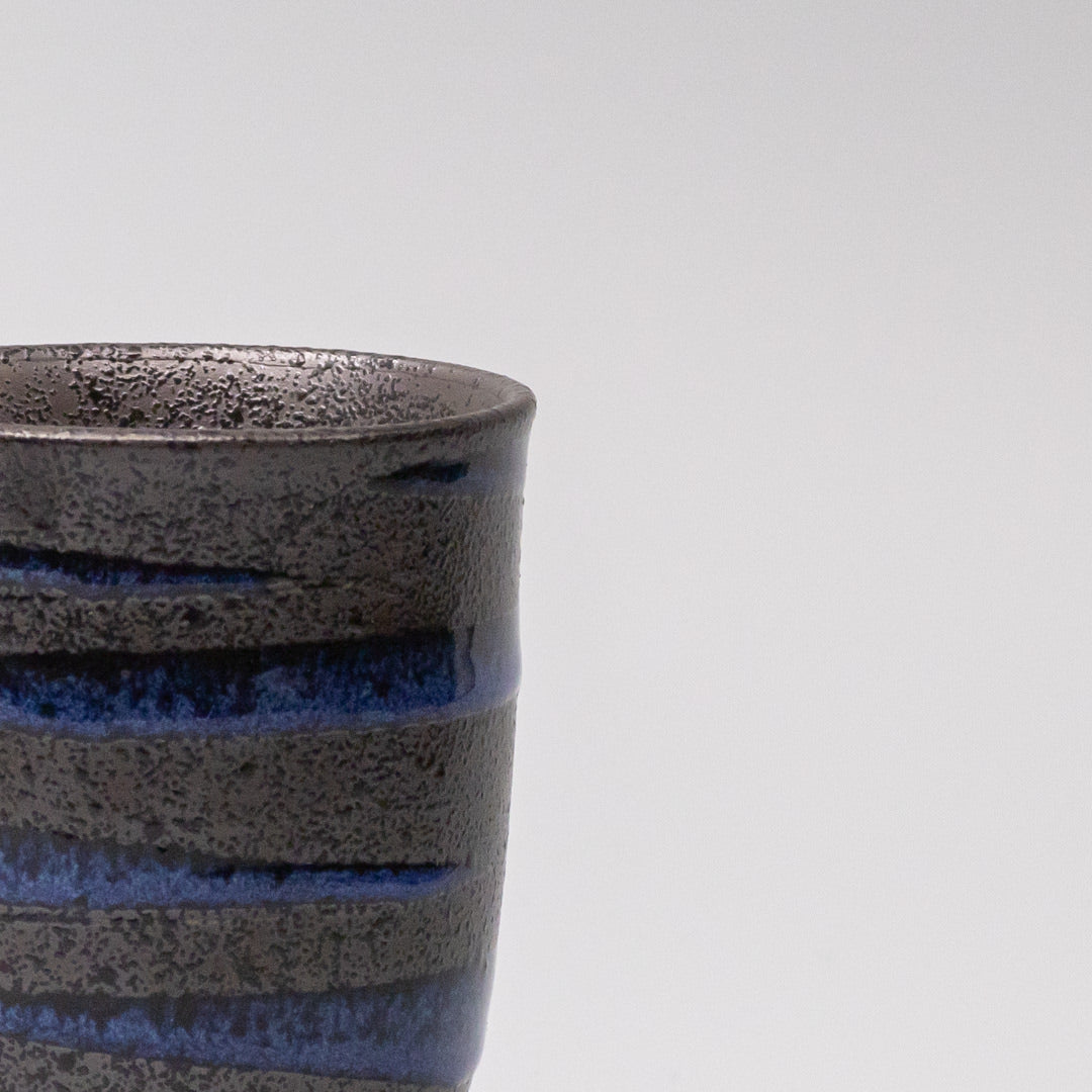 Handcrafted ceramic sushi mug with bright blue spiral pattern on black base, Japanese tableware for serving green tea, miso soup, or hot beverages